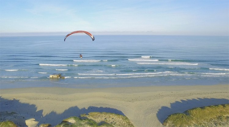 Paramoteur tijdens zonsopgang bij Finistère, Frankrijk gefilmd met drone